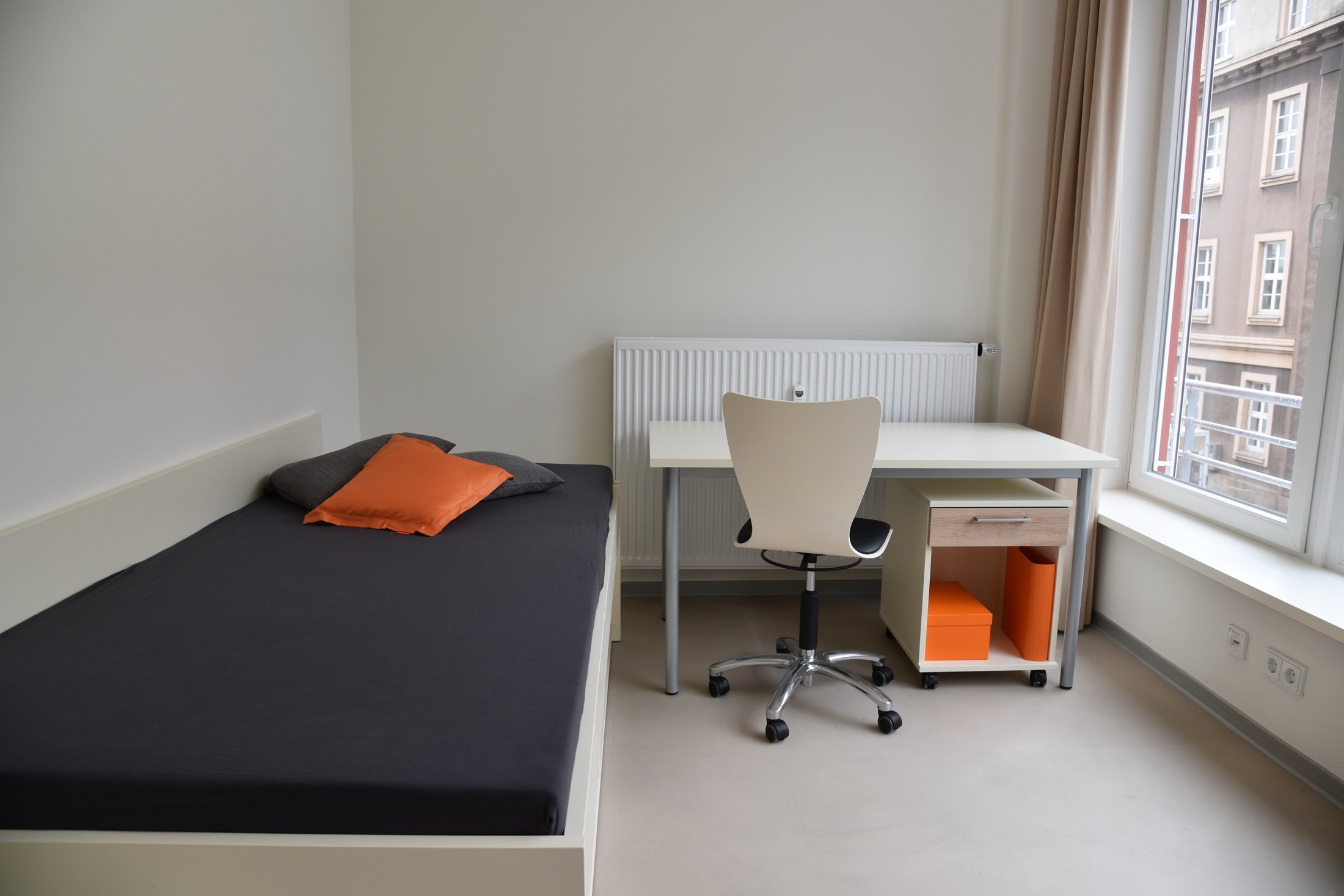 Helles Zimmer in einem Studierendenwohnheim in Hamm, mit Bett, Schreibtisch und Stuhl.