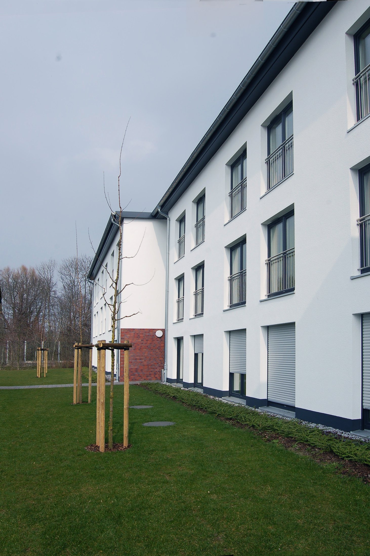 Studierendenwohnheim in Lippstadt mit modernen, weißen Fassaden und gepflegtem Gartenbereich.
