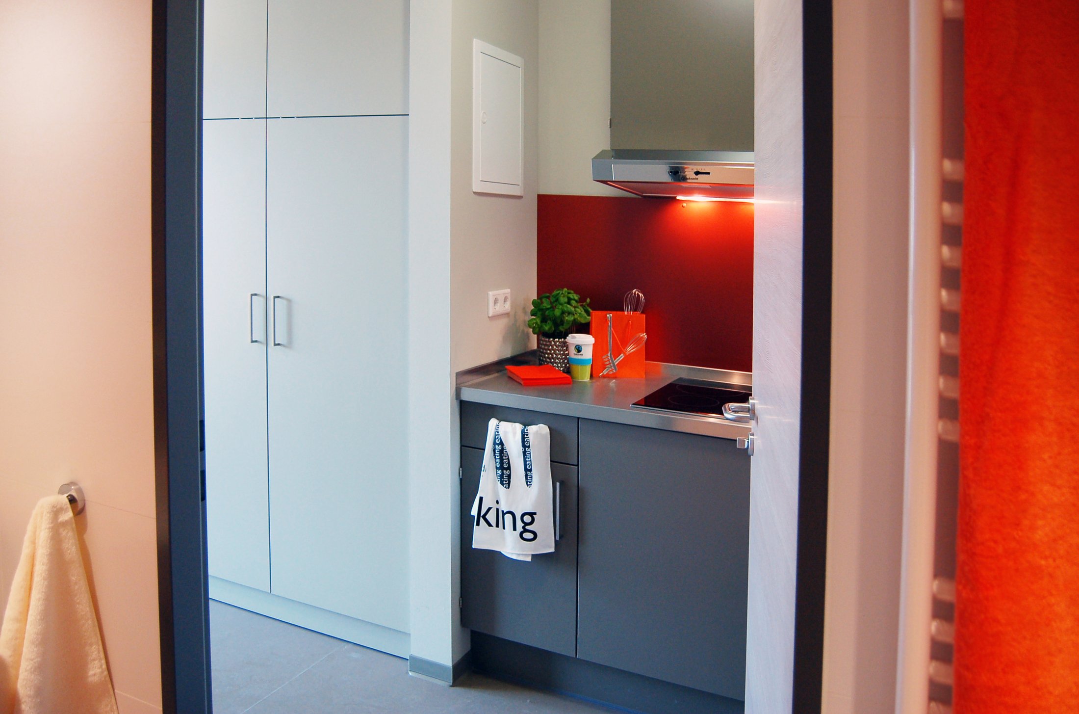 Küche eines Studierendenwohnheims in Paderborn - Alois Fuchs Weg mit modernen Geräten und orangefarbenen Akzenten.