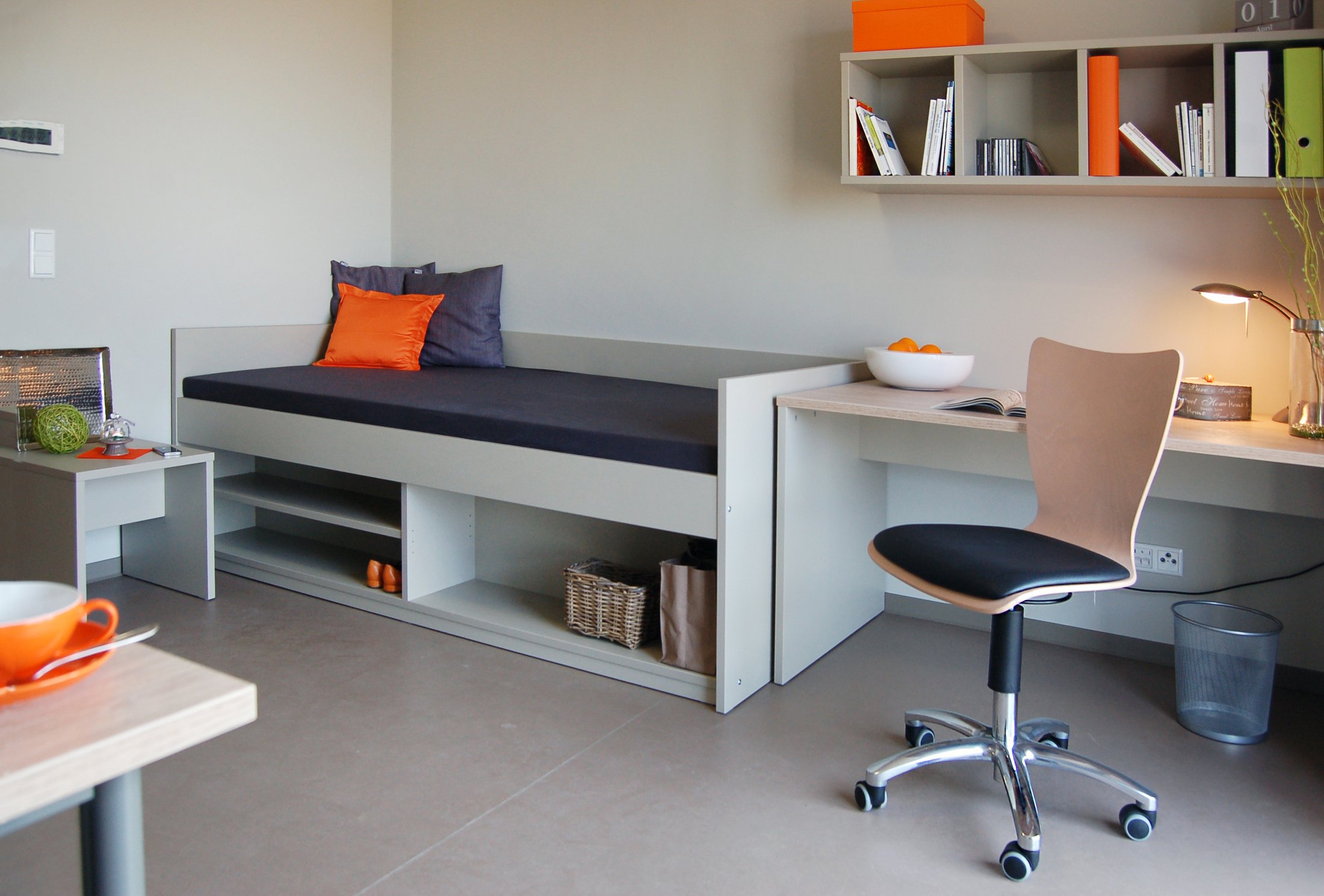 Modernes Zimmer im Studierendenwohnheim Paderborn-Alois_Fuchs_Weg, mit Bett, Schreibtisch und Stauraum.