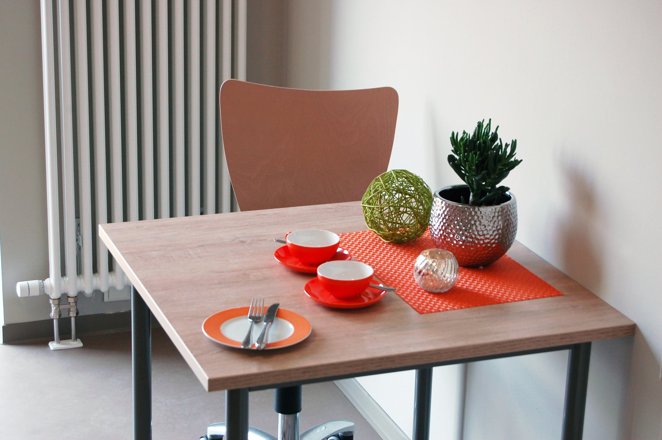 Moderne Küchenecke im Studierendenwohnheim Paderborn-Alois Fuchs Weg mit Tisch, Geschirr und Pflanzen.