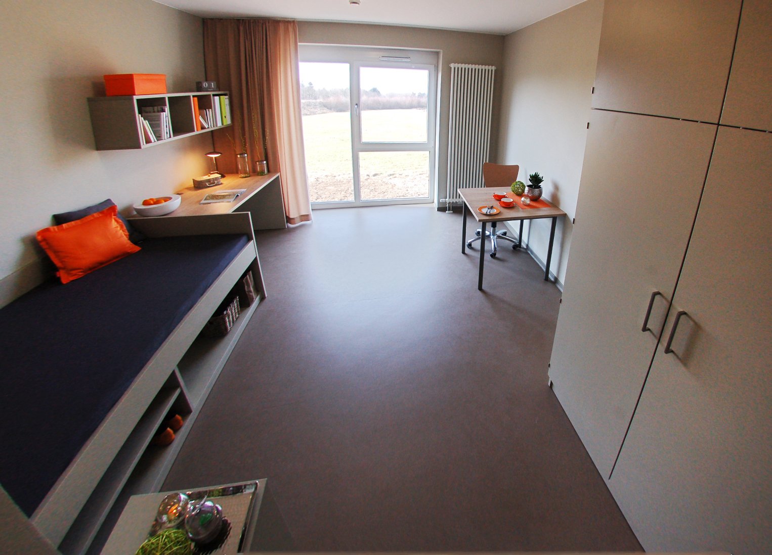 Helles Studierendenzimmer in Paderborn-Alois_Fuchs_Weg mit Bett, Schreibtisch und großen Fenstern.