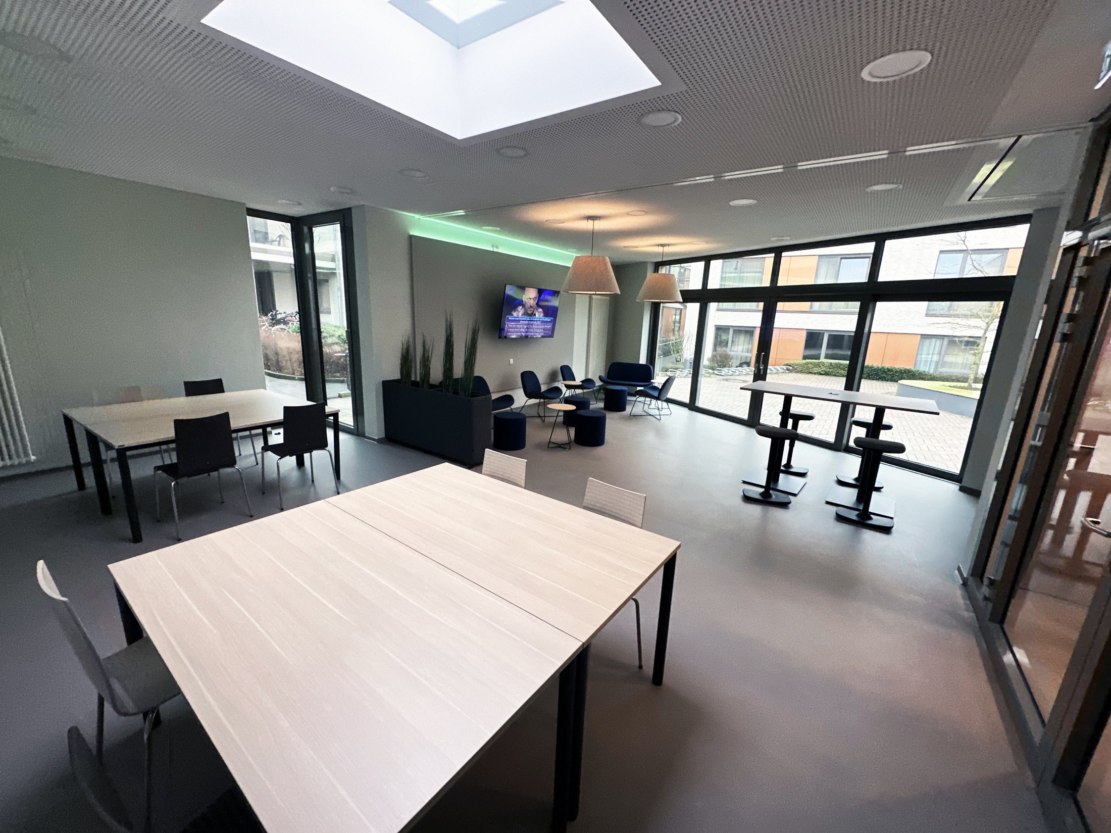 Moderne Gemeinschaftsräume im Studierendenwohnheim Paderborn - Lernraum Alois Fuchs Weg mit Tischen und Sitzgelegenheiten.