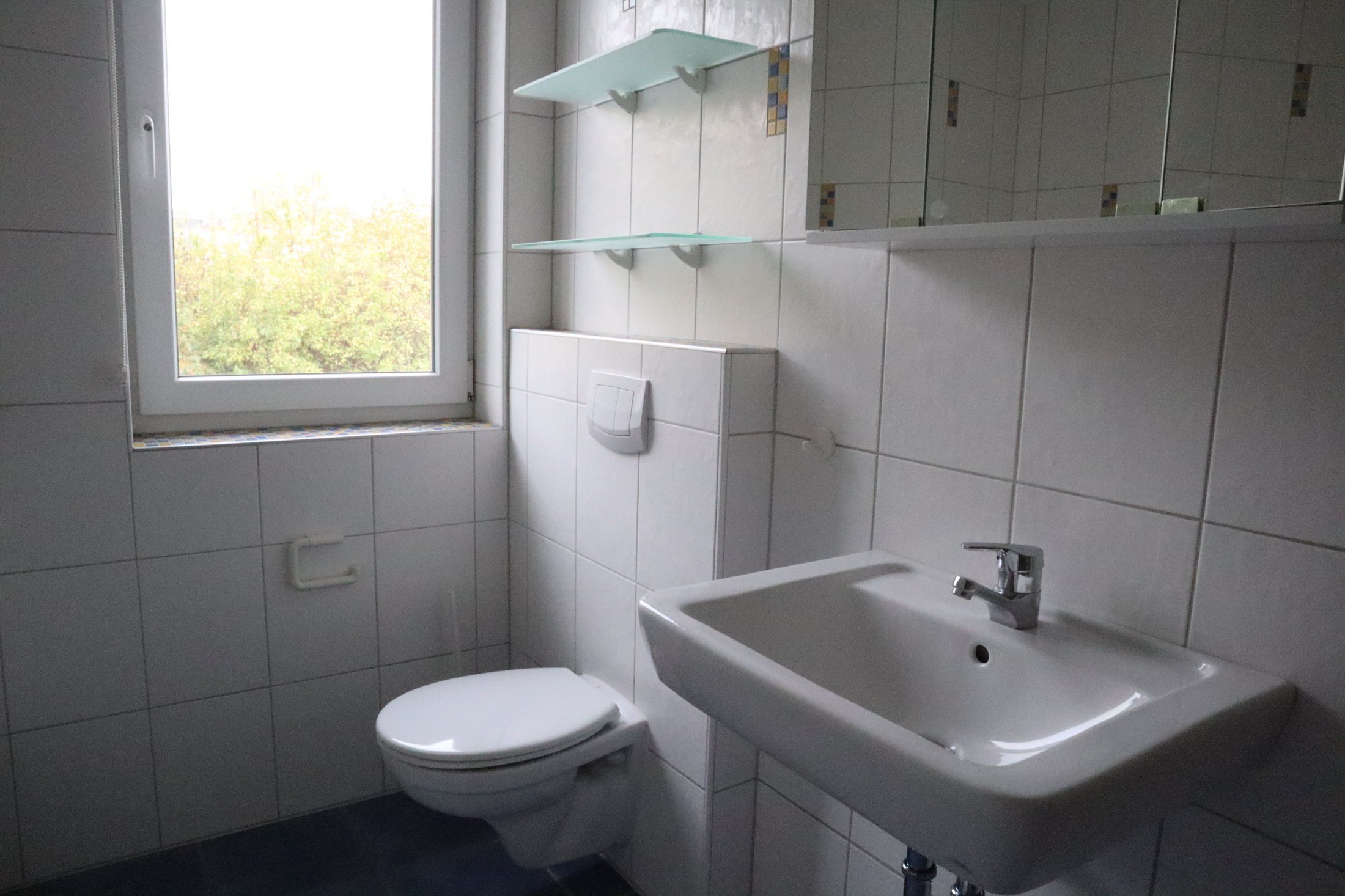 Badezimmer im Studierendenwohnheim Paderborn-Mersinweg_4 mit Toilette und Waschbecken, hellem Fensterblick.