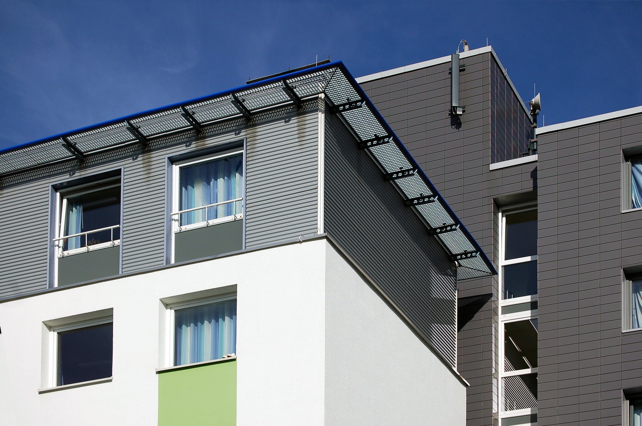 Studierendenwohnheim in Paderborn, Peter-Hille-Weg 13, moderne Architektur mit Fensterfronten und grauer Fassade.