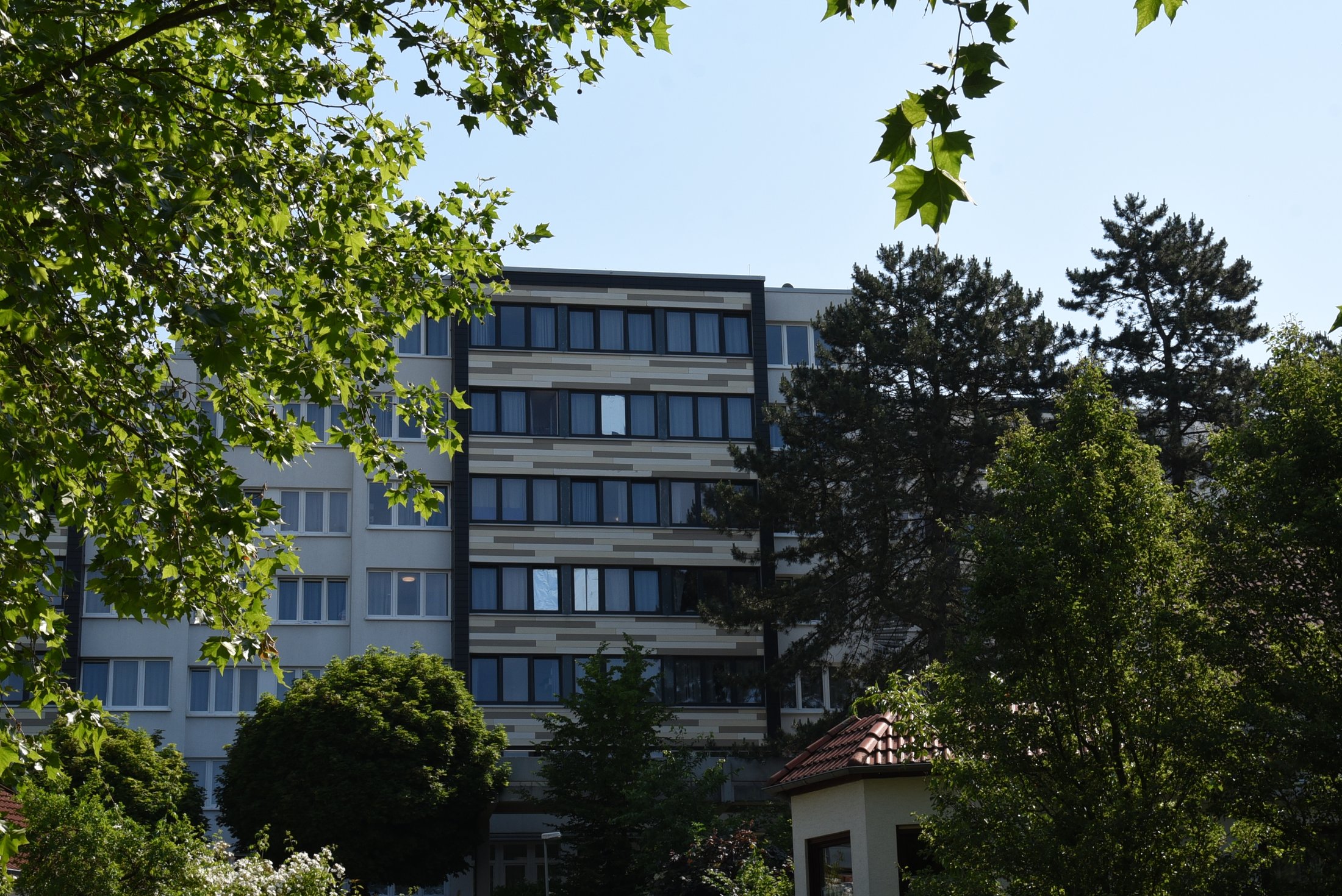 Studierendenwohnheim in Paderborn, Peter-Hille-Weg 13, umgeben von Bäumen und Grünflächen.