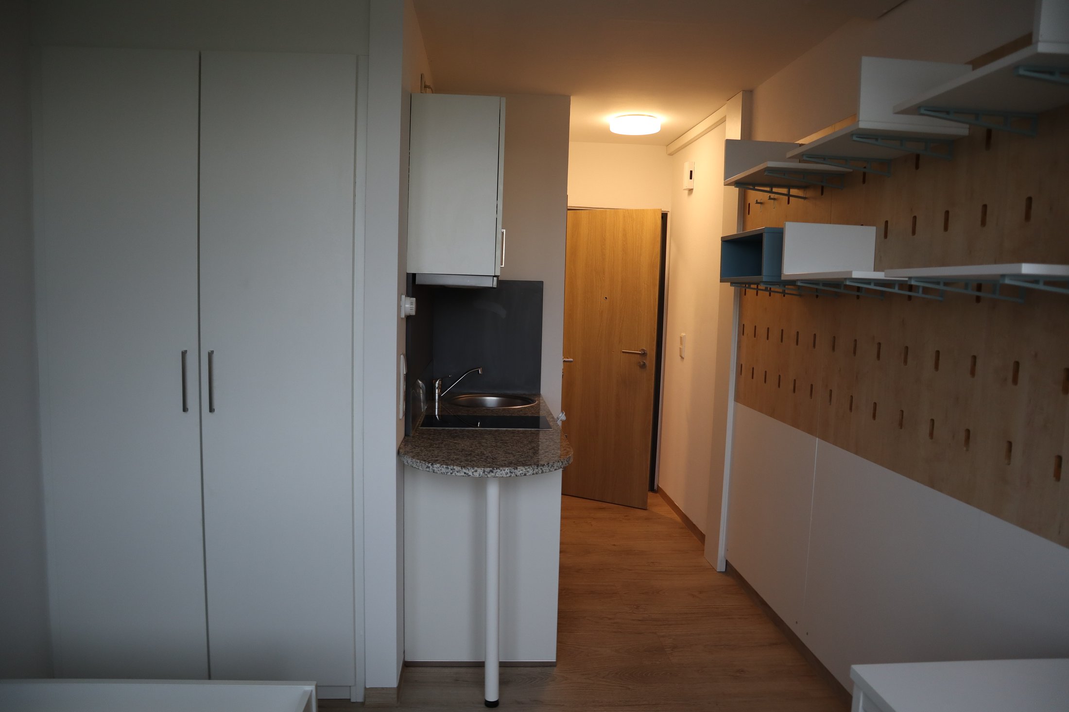 Modernes Zimmer in einem Studierendenwohnheim in Paderborn-Peter-Hille-Weg 13 mit Küche und Stauraum.
