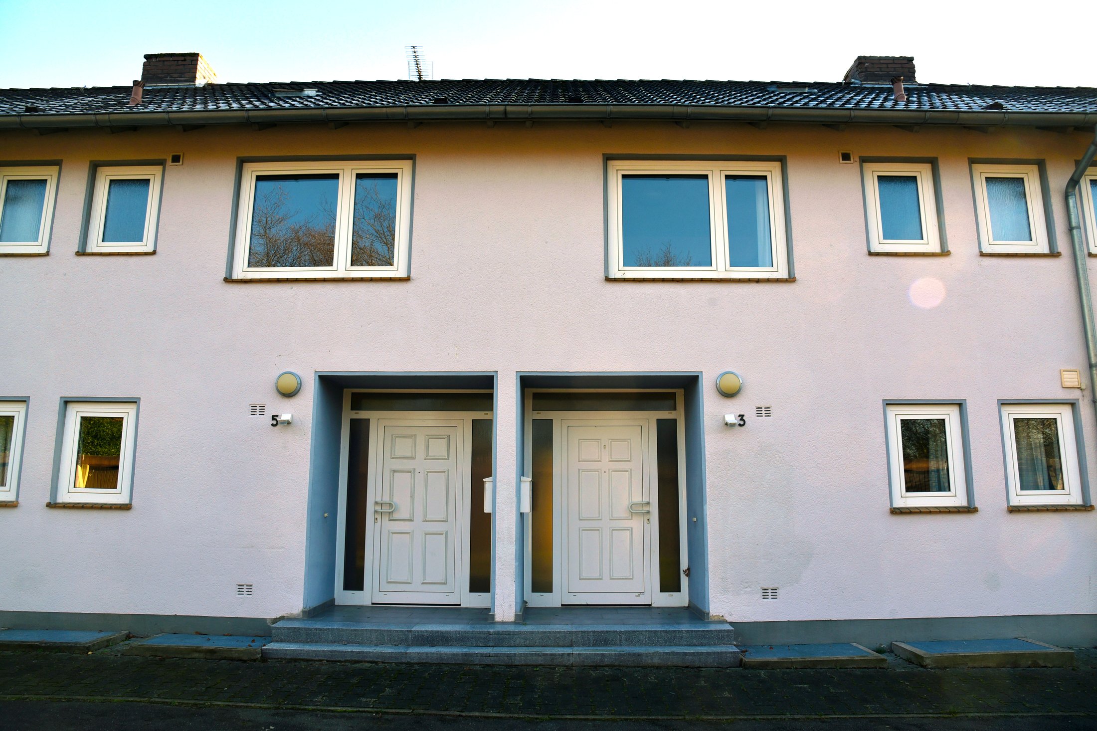 Studierendenwohnheim in Paderborn-Uhlandstraße mit zwei Eingängen und mehreren Fenstern an der Fassade.