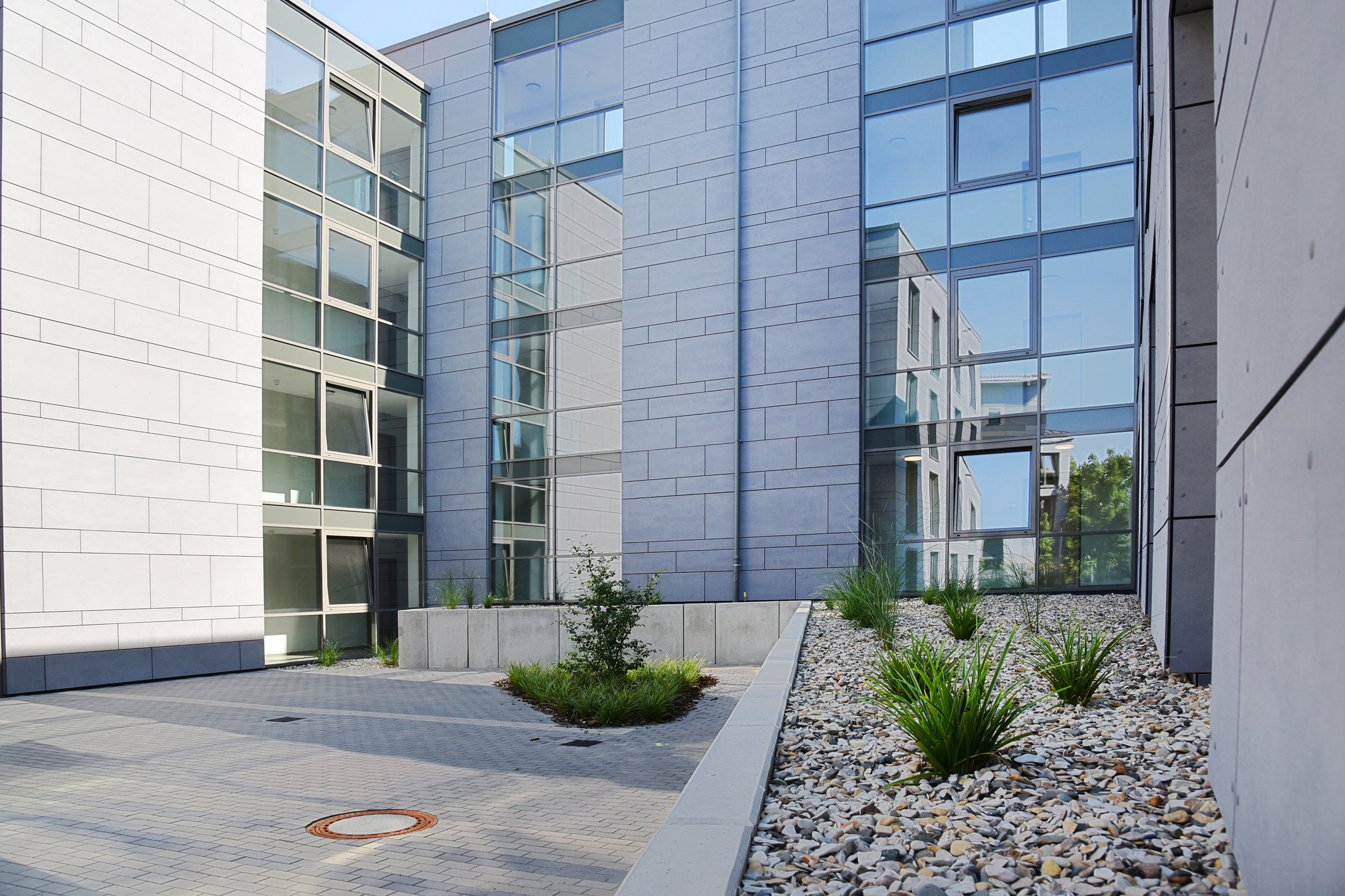Studierendenwohnheim in Paderborn-Vogeliusweg mit modernen, verglasten Gebäuden und begrüntem Innenhof.